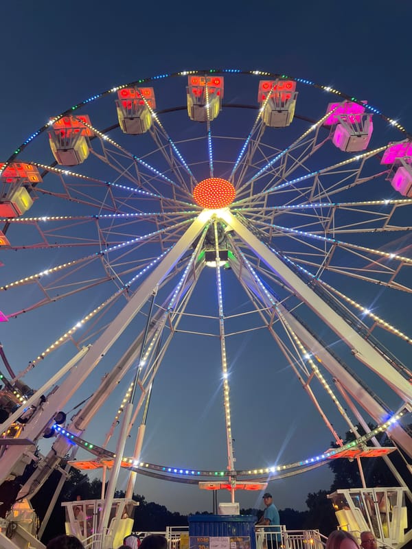 Fairground rides light up Tychy at dusk