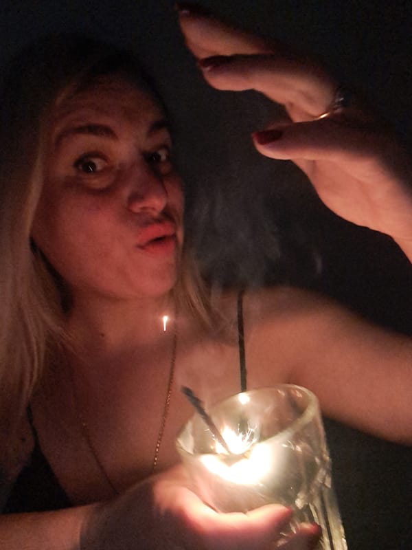 Woman holds sparkler in dimly lit setting in Elektrostal