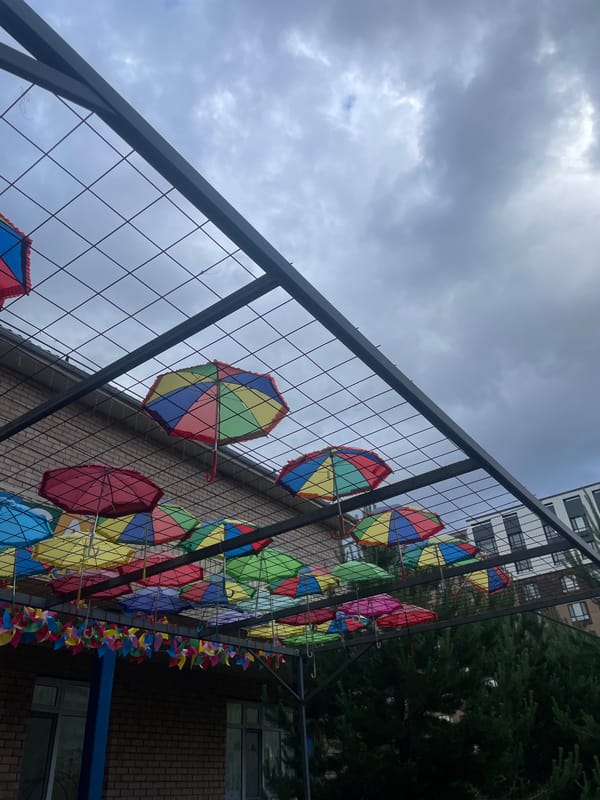 Colorful umbrellas and pinwheels decorate public fence in Astana