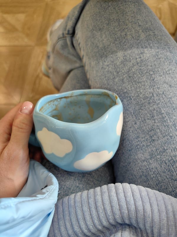 Person holds ceramic cloud mug in Domodedovo