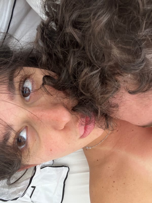 Person with curly hair photographed resting indoors in Milan