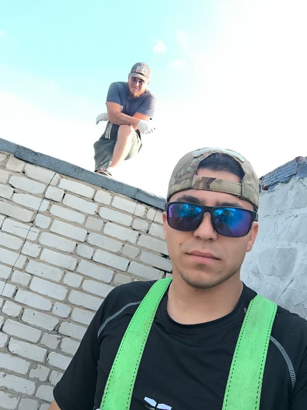Two men spotted on rooftop wearing safety gear