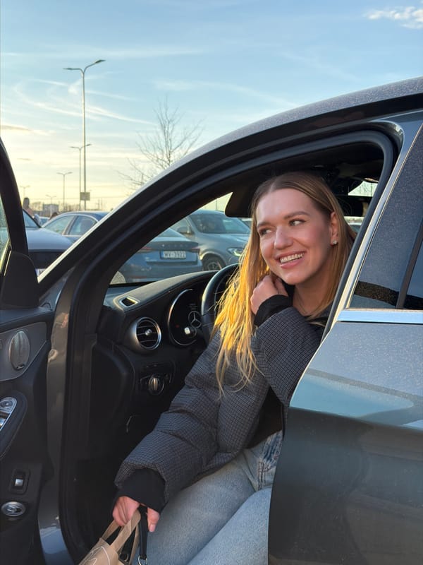 Women photographed at cars during sunset in Ulbroka, Latvia