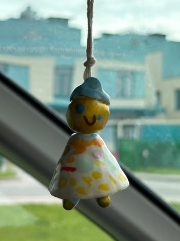 Handmade clay figurine hangs as car decoration in Strelna