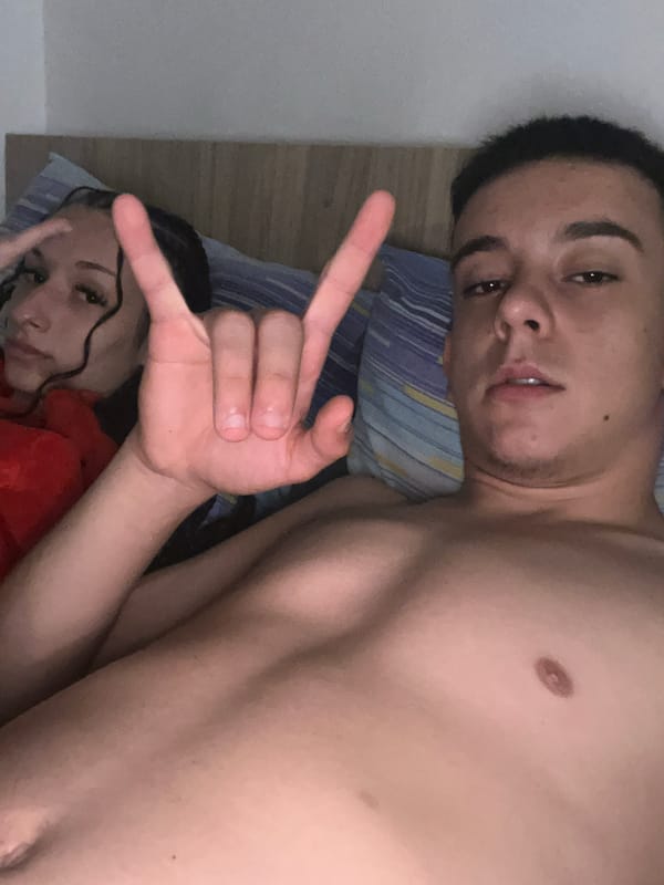 Two people rest together on striped bedding indoors