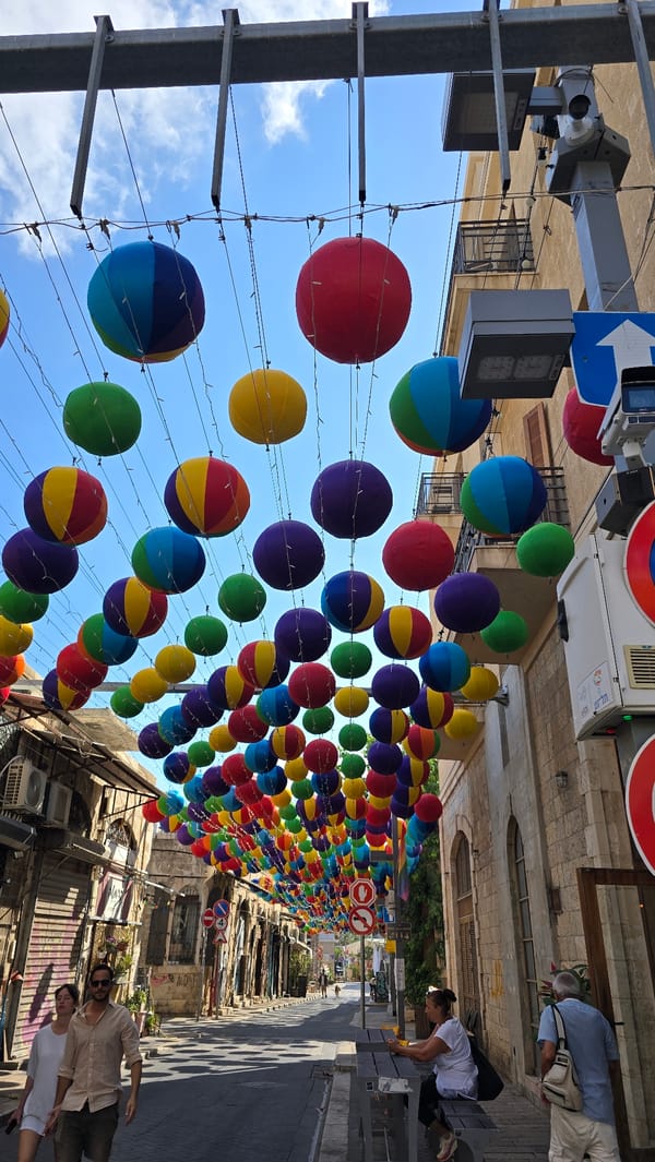 Colorful balloon canopy decorates a sunny Tel Aviv street