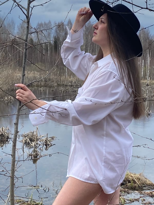 Woman observed by water near birch tree in Марковский