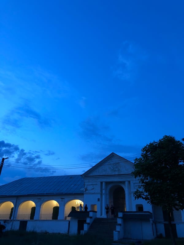 Twilight scenes around a lit colonial building and nearby streets