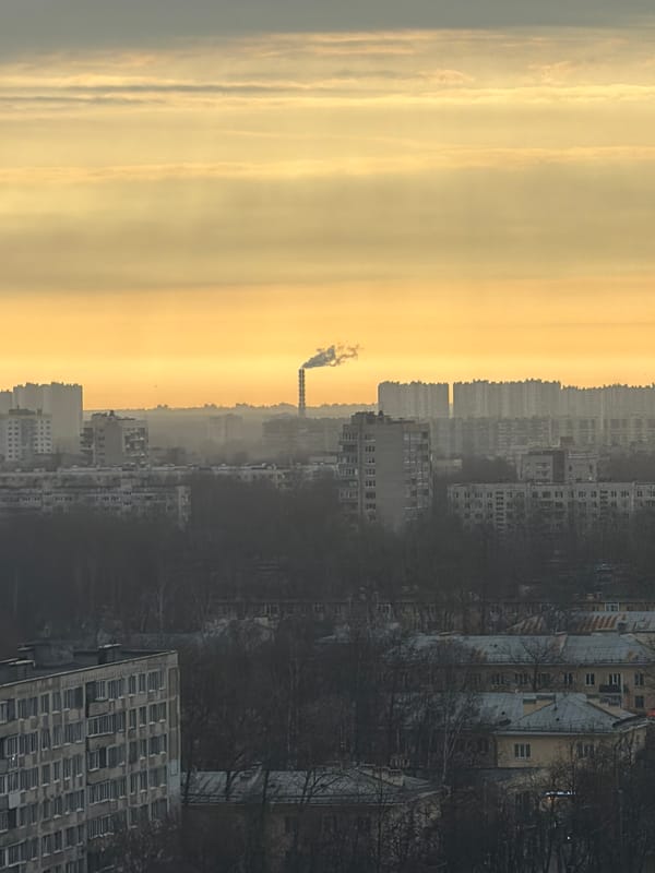 Industrial smokestack emits smoke over Saint Petersburg at dawn