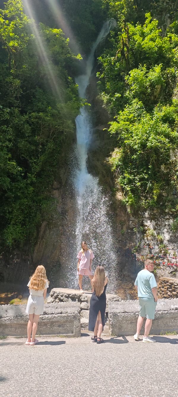 Tourists visit scenic waterfall in Abkhazia's mountain forest