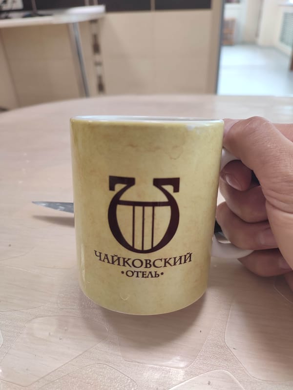 Man drinks morning beverage from ceramic mug indoors