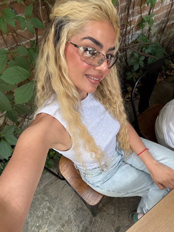 Woman Takes Multiple Mirror Selfies Near Urban Restaurant