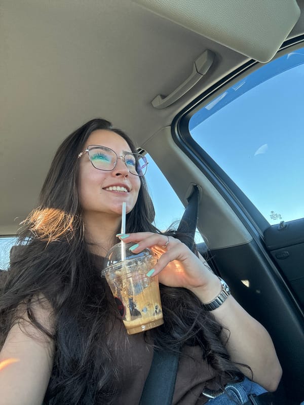 Woman drinks beverage in car with open sunroof in Piperevo