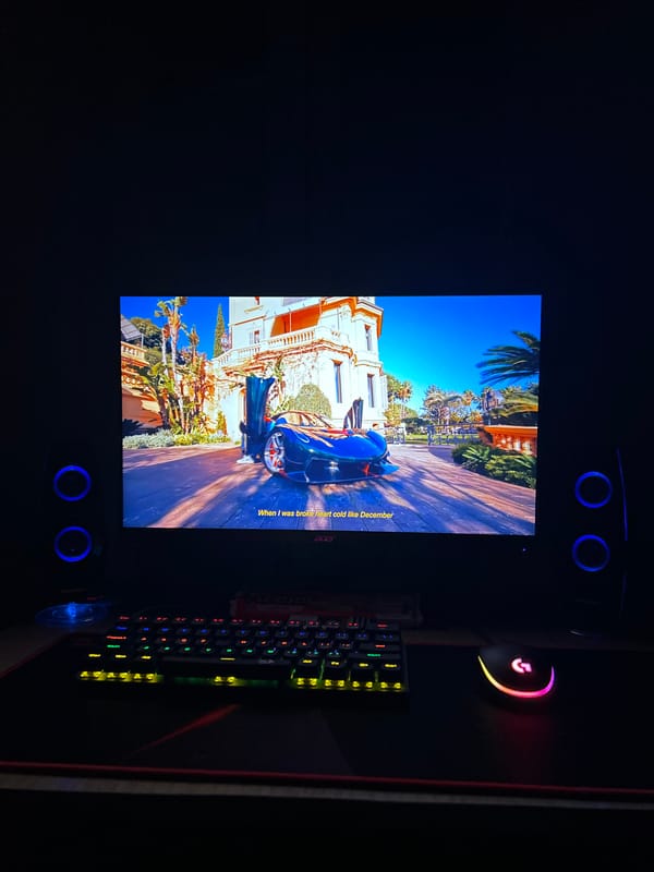 Computer monitor displays blue car scene in dark room