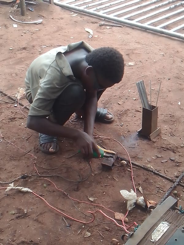 Metal workers weld outdoors in Owerri workshop