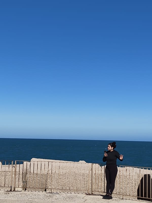 Tourists visit Dénia lighthouse pier on clear afternoon