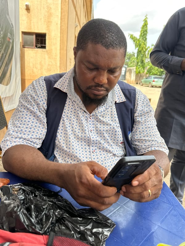 Man uses smartphone at outdoor table in Shaba