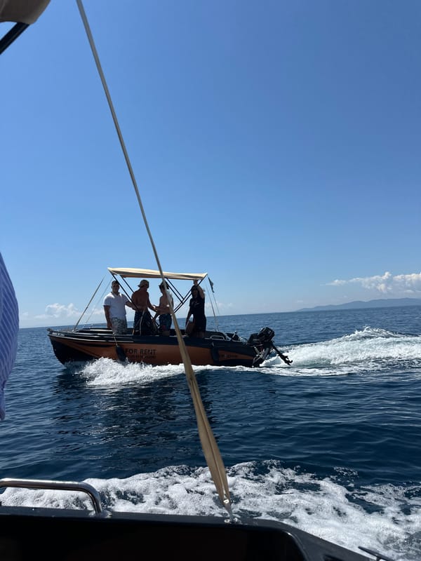 Small orange boat out on the Greek sea on a clear day