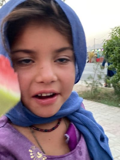 Girl enjoys watermelon in Kandahar