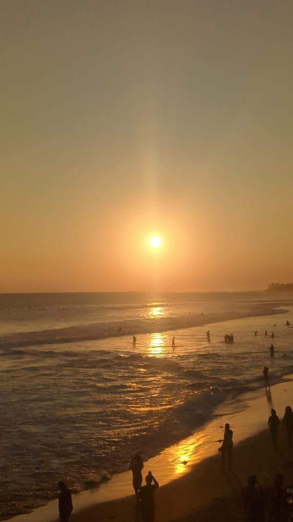 Sunset documented at North Kuta beach with musician, cafe patrons