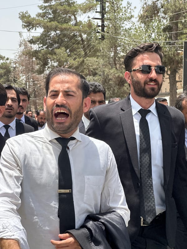 Formal procession, likely lawyers, marching through Quetta streets