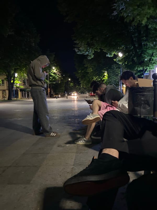 Young people gather on nighttime street in Ruse, Bulgaria