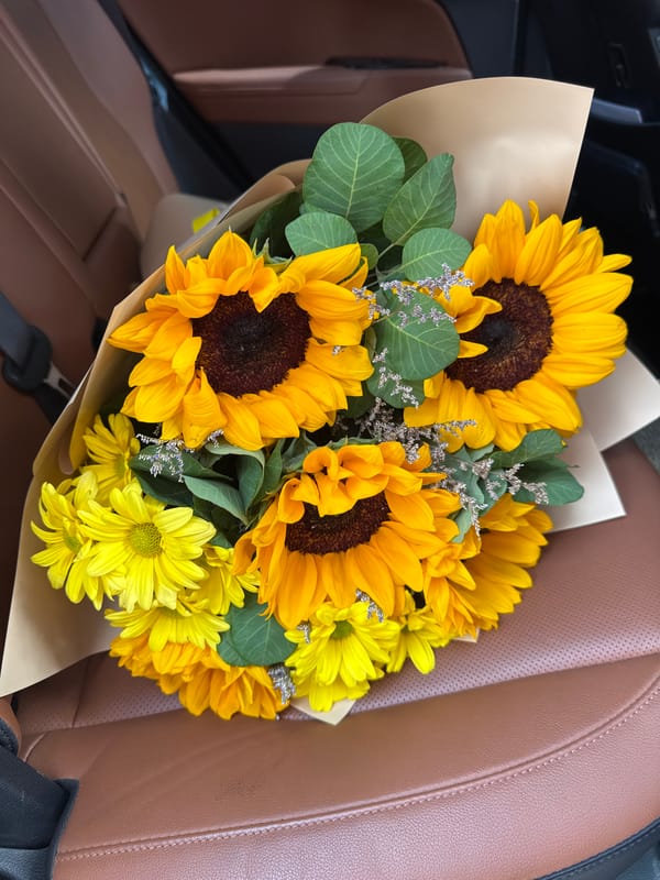 Sunflowers and peonies wrapped and ready in an Almaty car