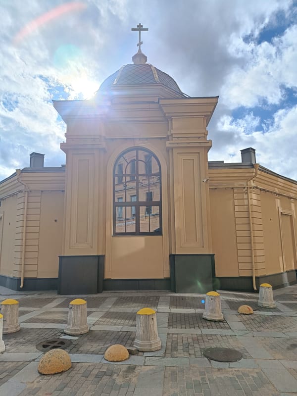 Religious building with cross-topped dome observed in urban area