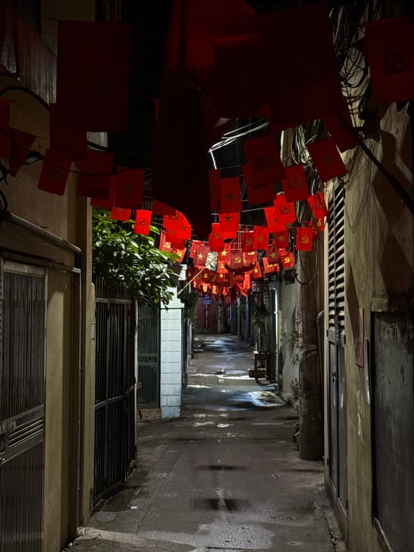 Communist flags decorate narrow Hanoi alleyway