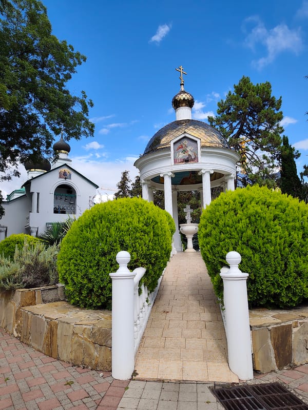 White church and golden rotunda in Sochi's summer greenery