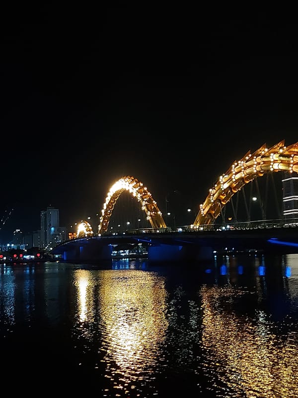 Dragon Bridge glows gold over Da Nang at night