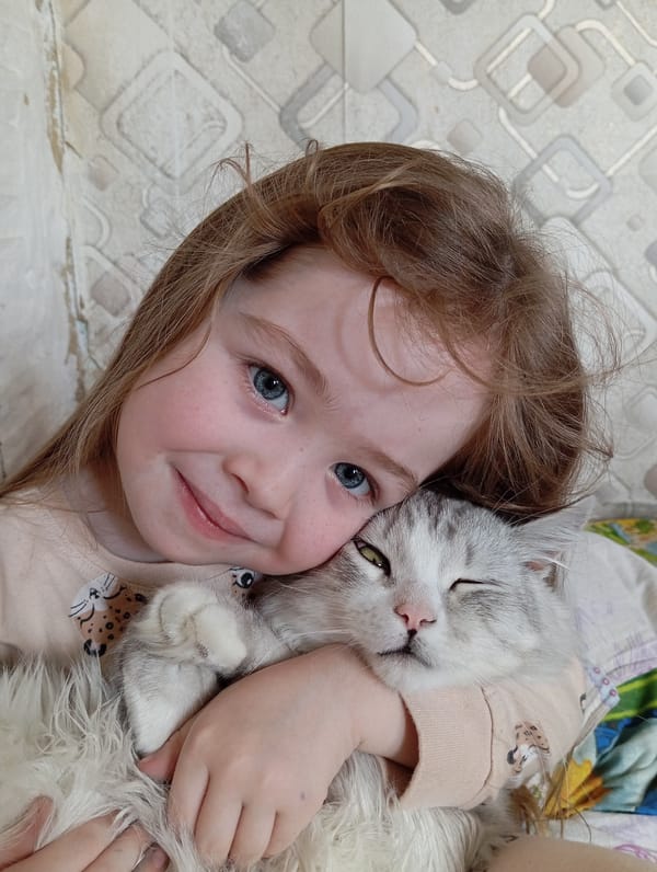Child cuddles cat in tender morning moment in Russia