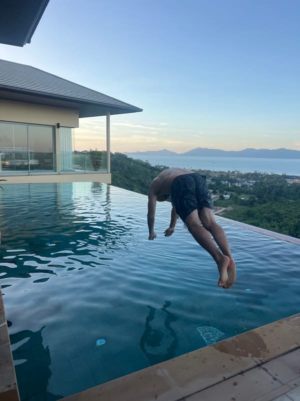 Men enjoy pool activities at Thai hillside resort