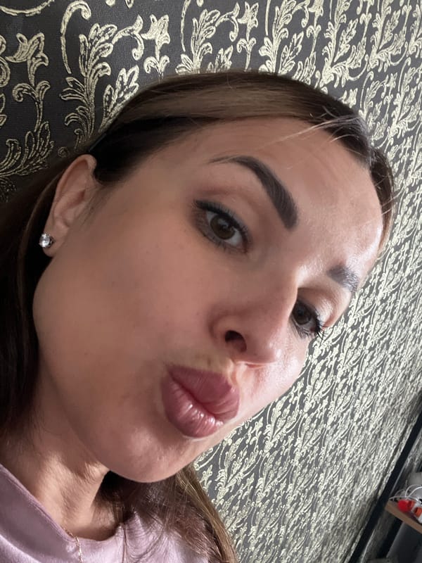 Casual selfie session on a patterned sofa with gold wallpaper
