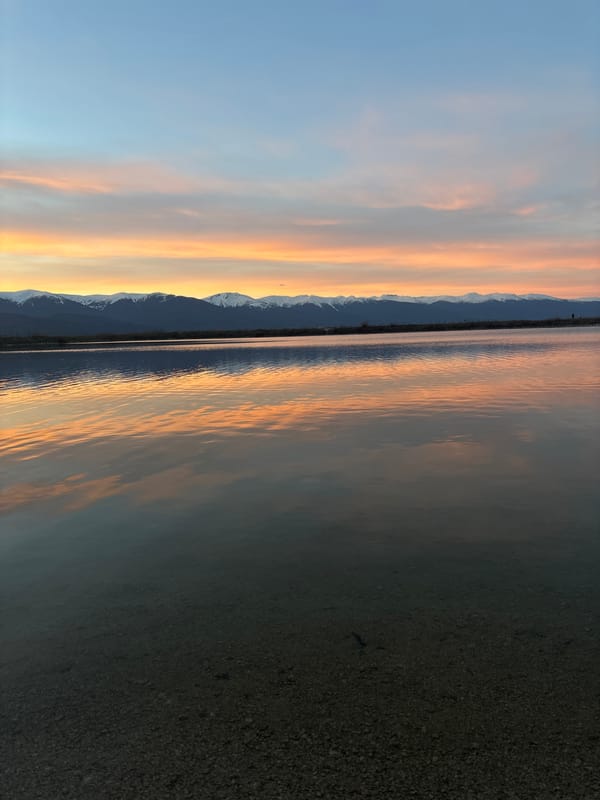 Sunset reflects over water near Dobrinishte, Bulgaria mountains