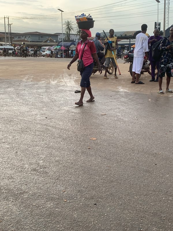Wet afternoon street life along a Shagamu market thoroughfare