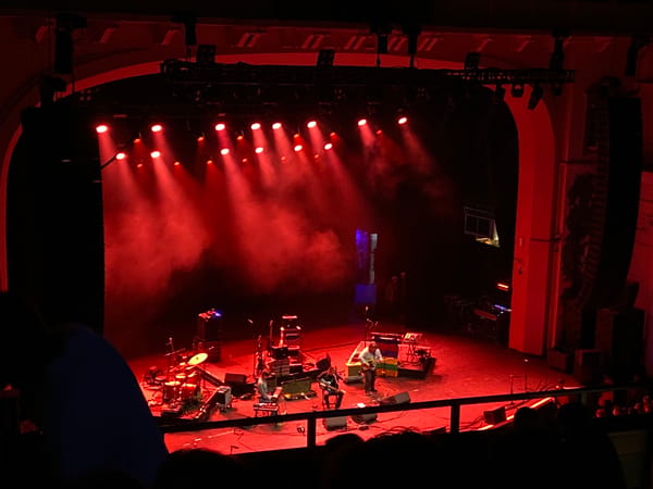 Band performs at London venue with colored lights, smoke