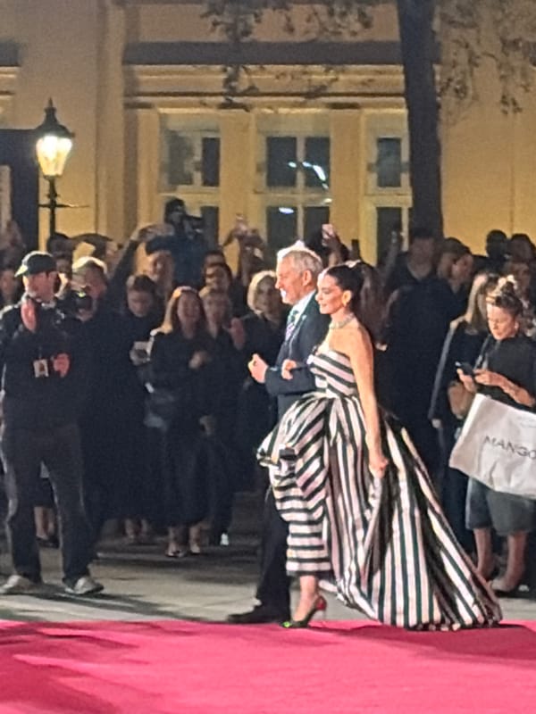 Woman in striped dress attends nighttime London fashion event