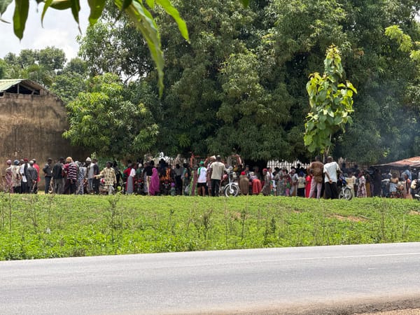 Large crowd gathers roadside under trees in Akwanga, Nigeria