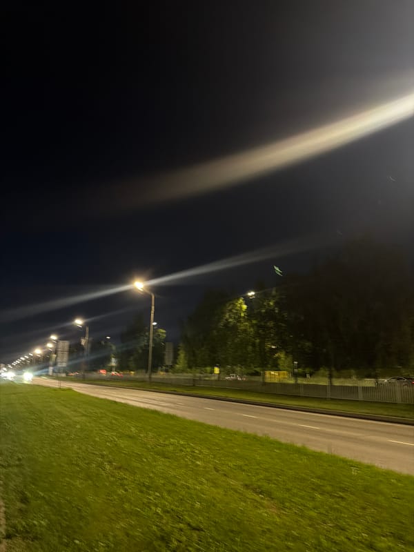 Person enjoys green drink on illuminated Naberezhnye Chelny street
