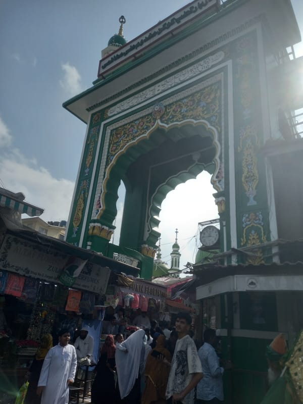Ornate archway observed at bustling Mumbai market near religious site