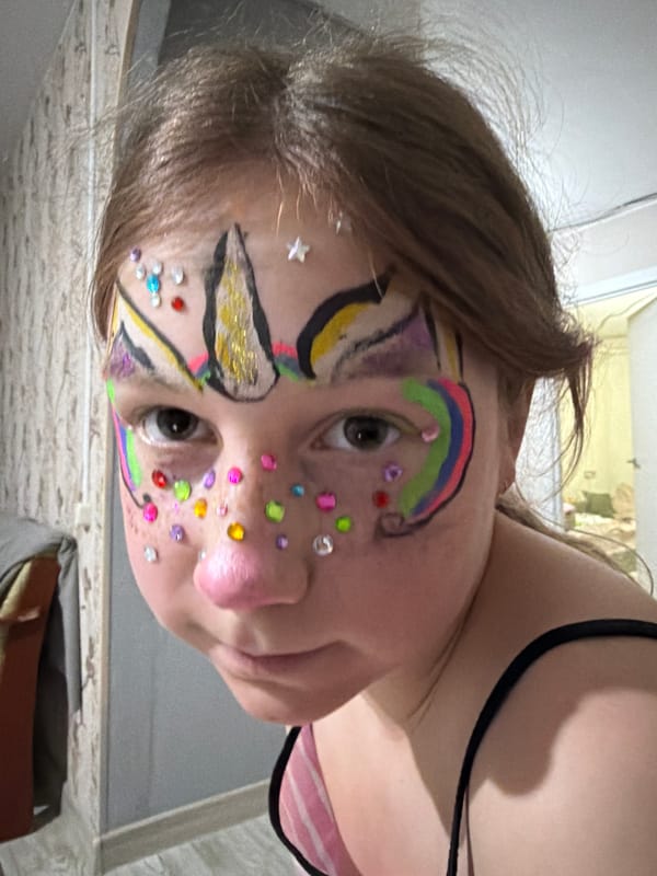Family gathering with face-painted child around fireplace in Markovo