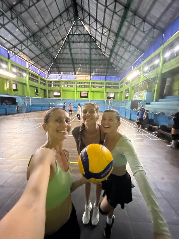 Women play volleyball at indoor gym in Ubud
