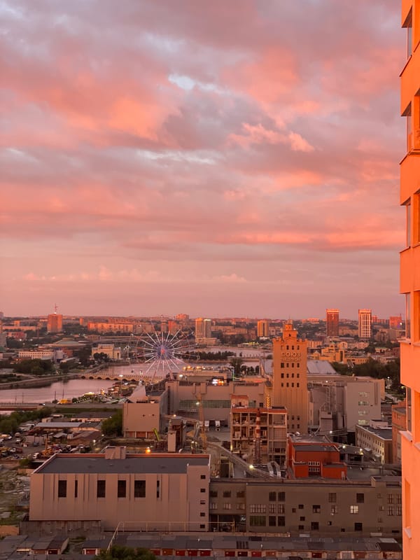 Sunset rainbow over a dense city skyline