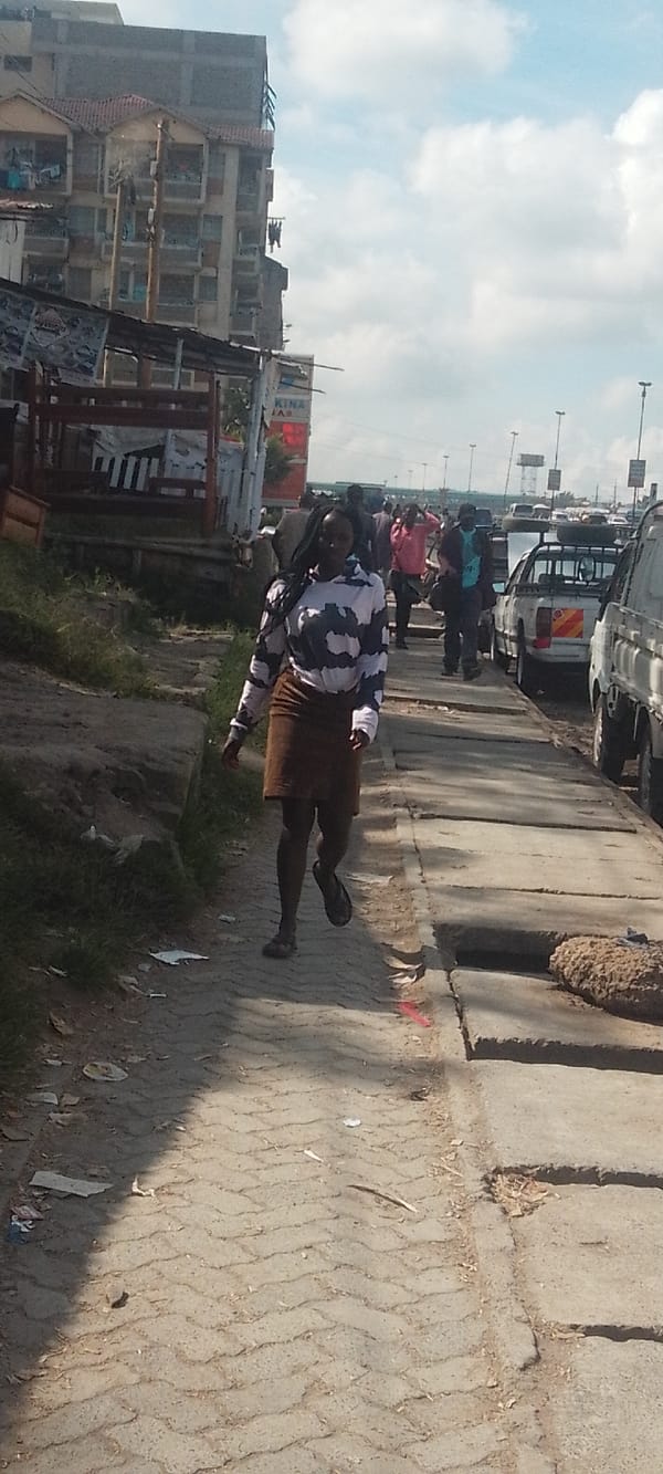 Woman walks Nairobi street during morning hours