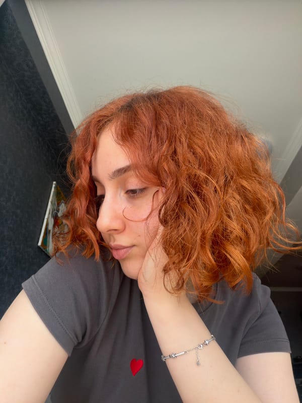 Person with red curly hair photographed multiple times in Tbilisi