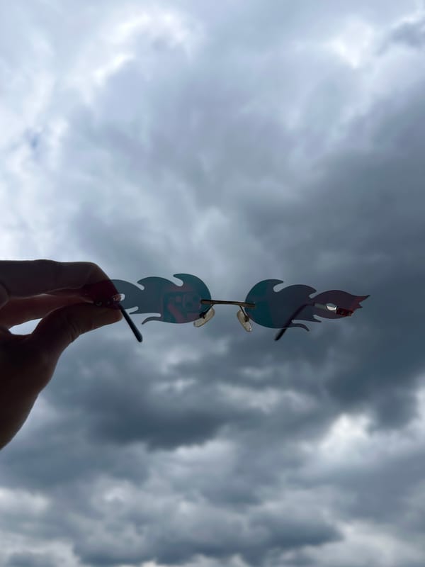 Person displays metal wind chime against stormy sky in Bulgaria