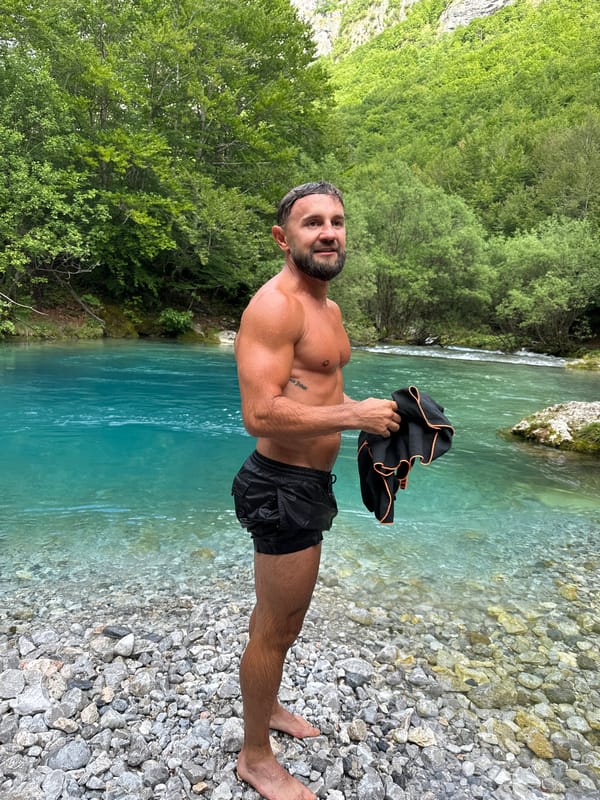 Man enjoys afternoon swim in Montenegro's turquoise mountain river