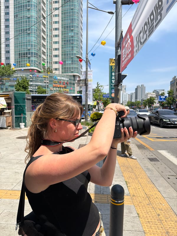 Woman photographs Seoul street scene in early morning hours