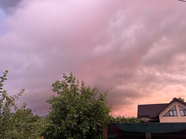 Dramatic storm clouds roll over a residential neighborhood at golden hour.